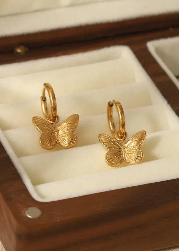 A pair of gold-plated stainless steel butterfly drop earrings with a removable butterfly charm, displayed in a clear case.