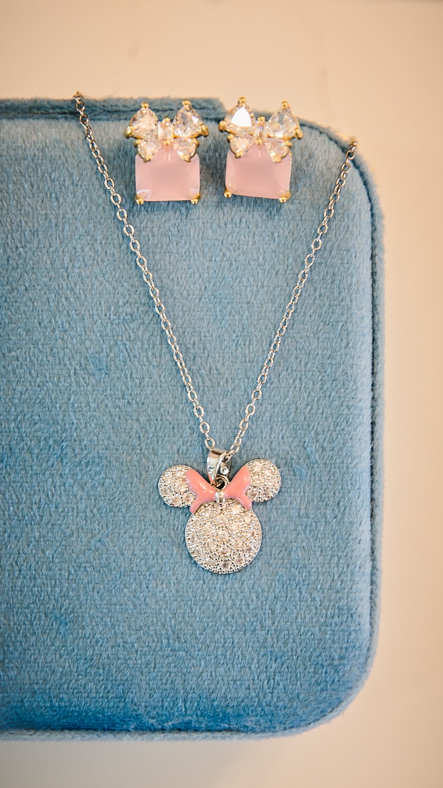 Pink enamel bow necklace paired with matching stud earrings featuring pavé cz stones, dainty chain, and feminine everyday jewelry styling