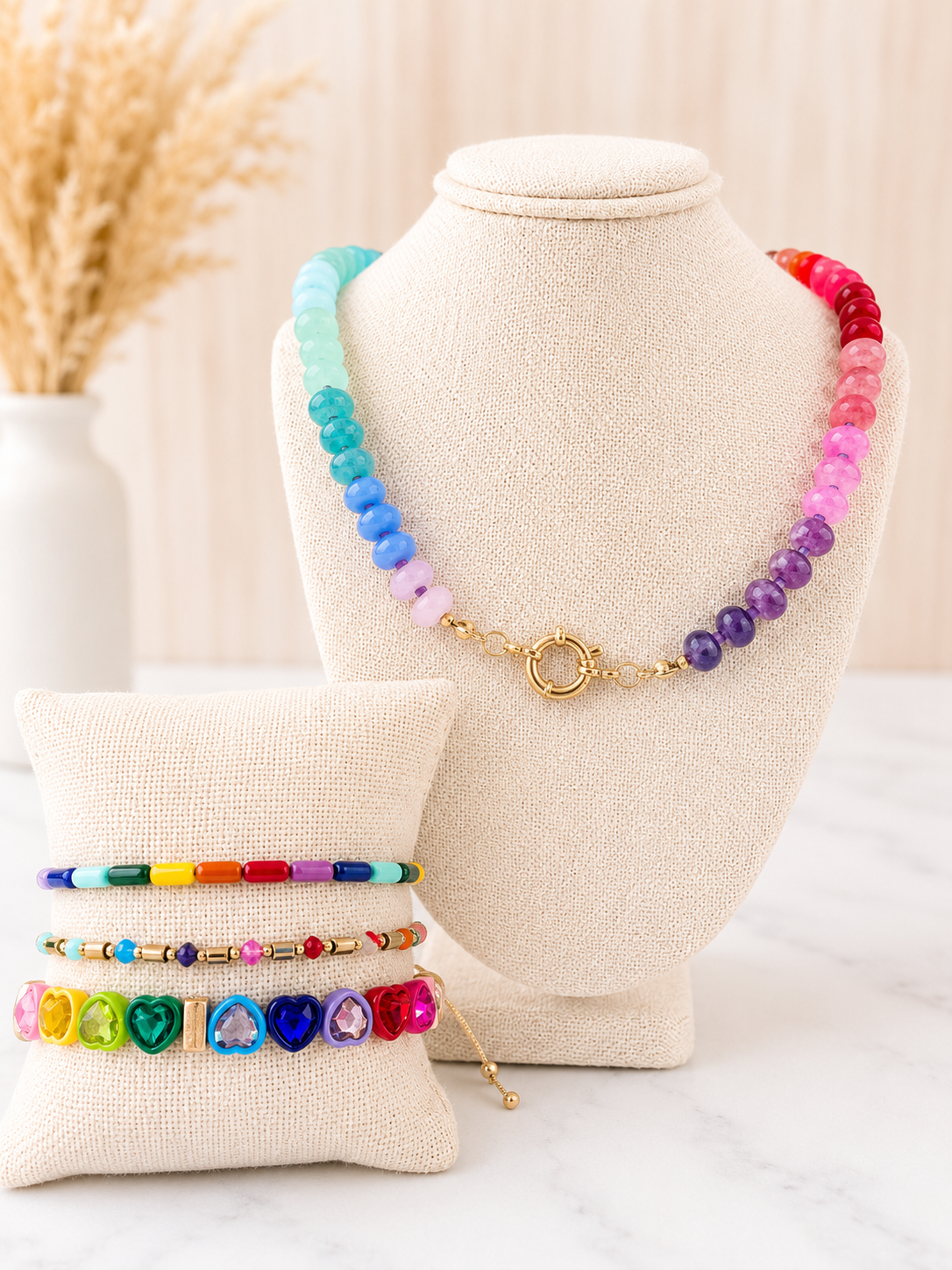 Rainbow Natural Stone Necklace with gold clasp on jewelry bust, styled with colorful beaded bracelets