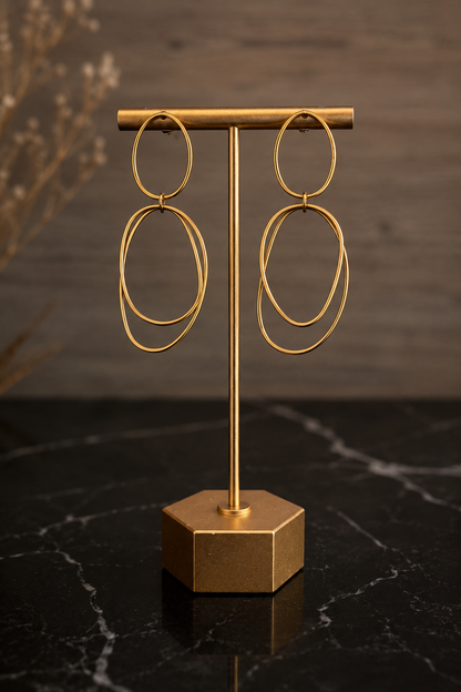 Afterglow Earrings featuring elongated organic gold hoops crafted from stainless steel with 18kt gold PVD plating.