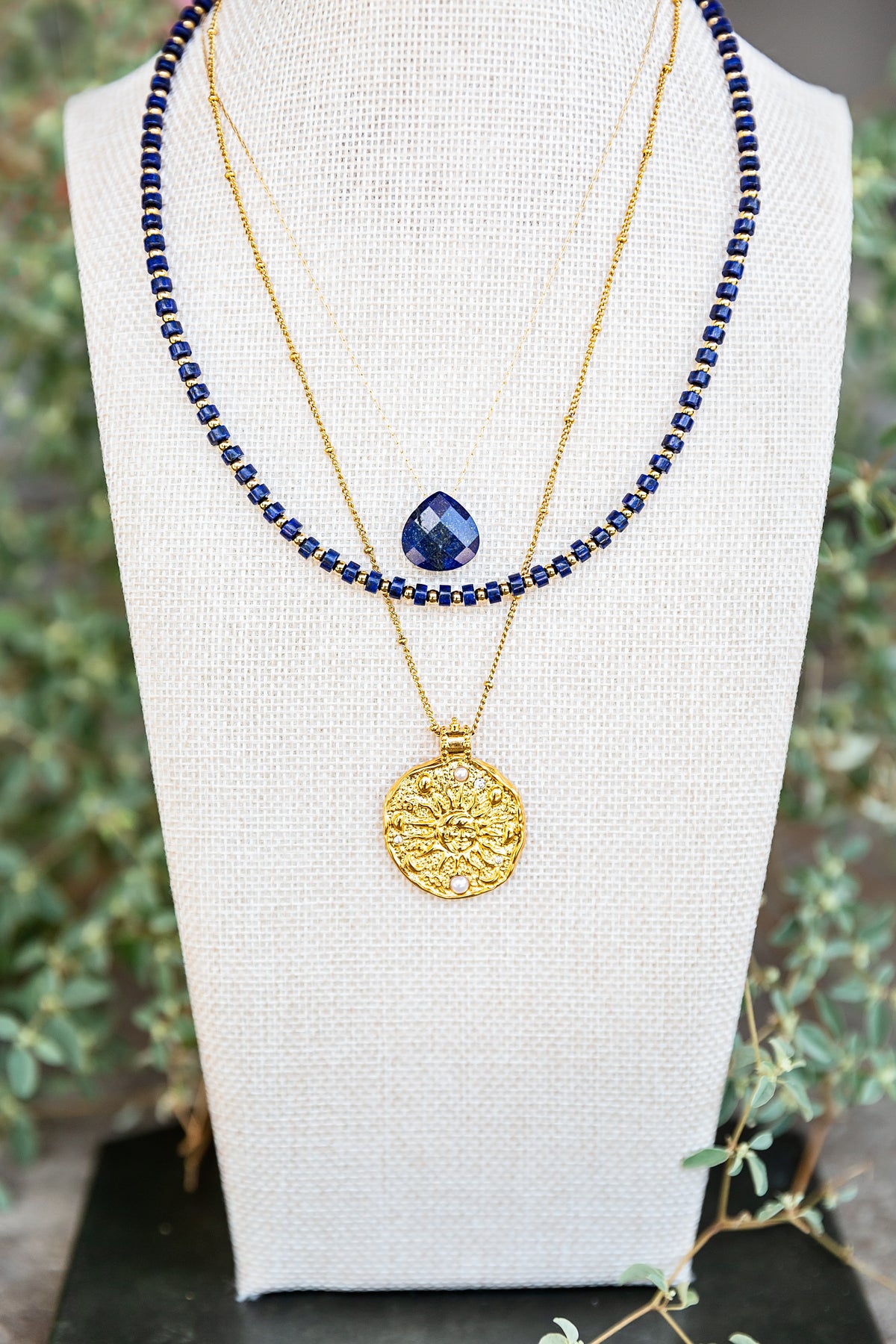Gold Solana Necklace layered with a blue pendant necklace from the Alchemy Collection Fall 2026