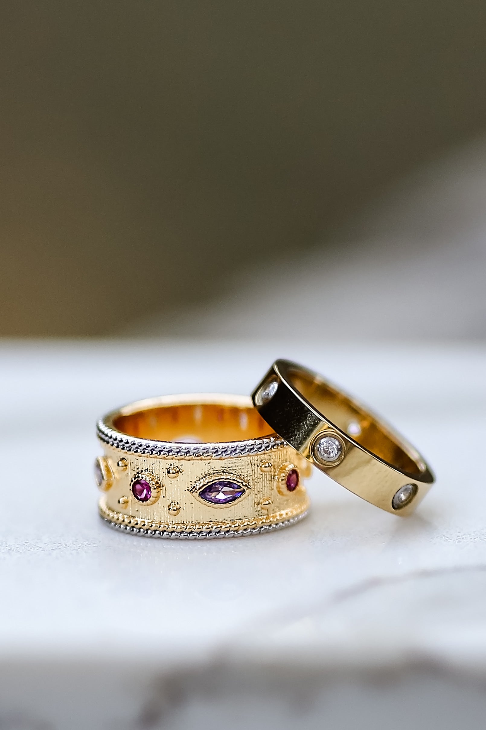 Angled view of gold ring showing textured band and multicolor stones