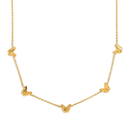 Close-up of delicate gold butterfly charms along a fine chain necklace