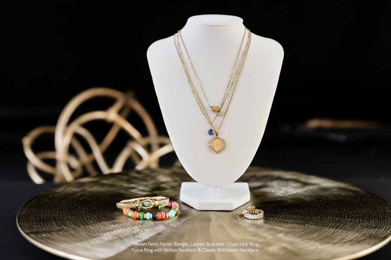 Necklaces on a white bust with rings on a wooden surface