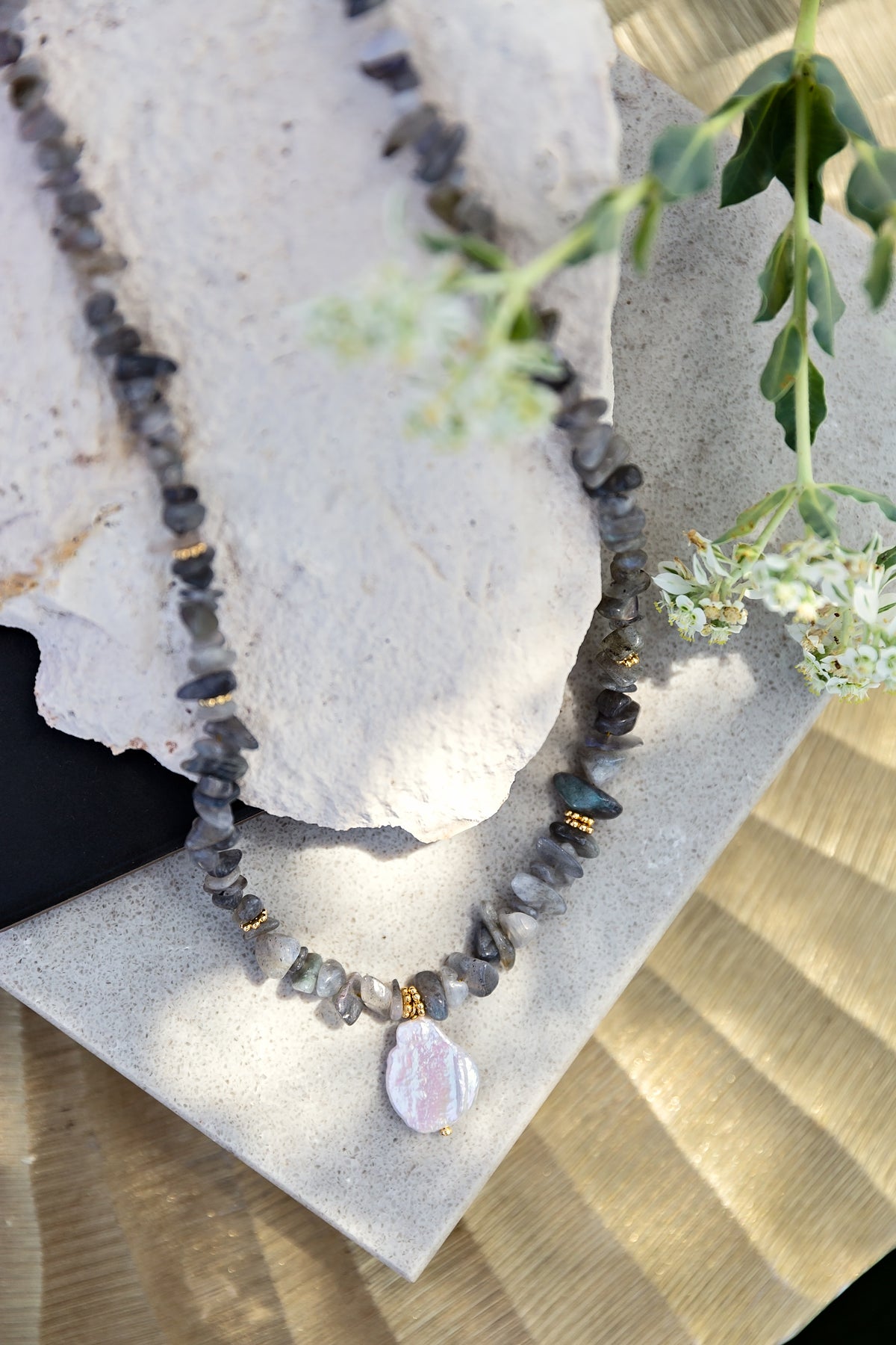 Boheme Necklace in Grey from the LUNA Collection by VEITA Jewelry featuring natural grey stone chips, gold-tone spacer beads, and a mother-of-pearl pendant.