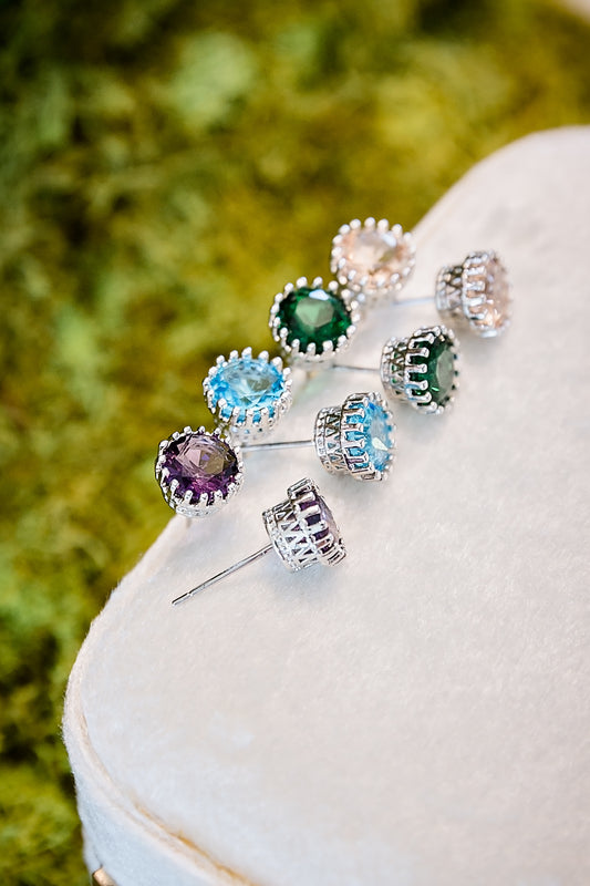 Assorted colored zircon stud earrings displayed together on jewelry stand
