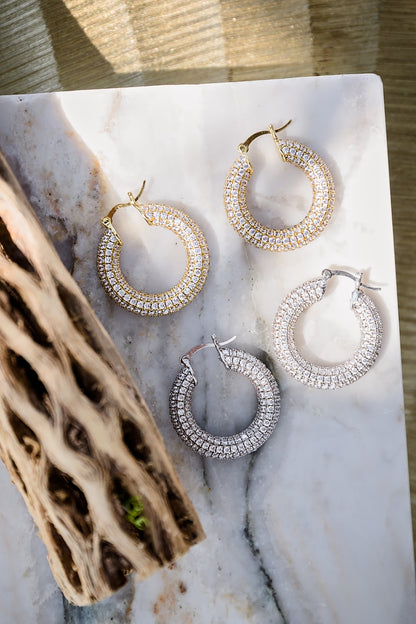 Charlotte pavé hoop earrings featuring gold and silver metal options with shimmering crystal detail on round hoop design