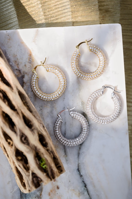 Charlotte pavé hoop earrings featuring gold and silver metal options with shimmering crystal detail on round hoop design