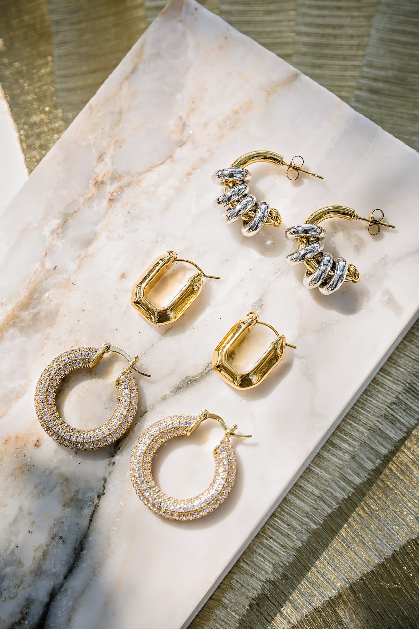 Charlotte pavé hoop earrings displayed in multiple styles showing gold and silver options with full crystal coverage