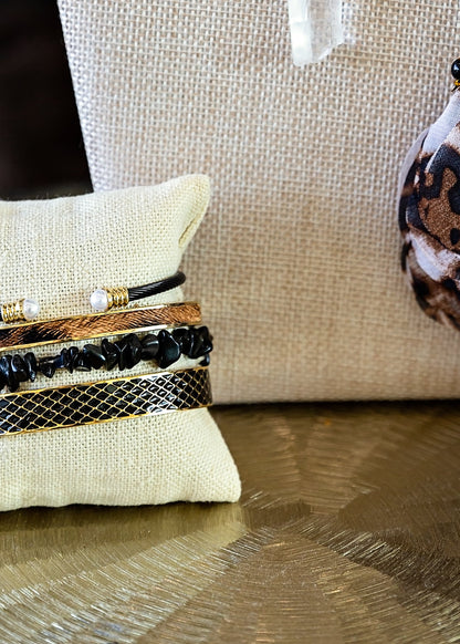 Cheetah Bangle paired with coordinating gold and mixed-metal bracelets in a layered jewelry stack.