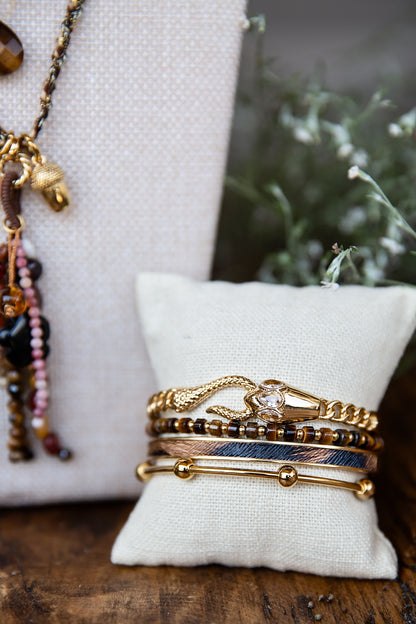 Cheetah Bangle styled with a layered collection of VEITA bracelets on a jewelry display.