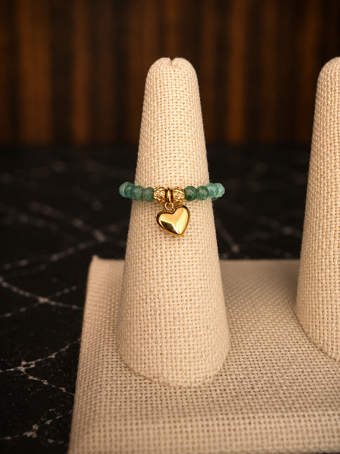 Claire Stretch Ring featuring African jasper faceted gemstone beads and a gold heart charm displayed on a ring cone.