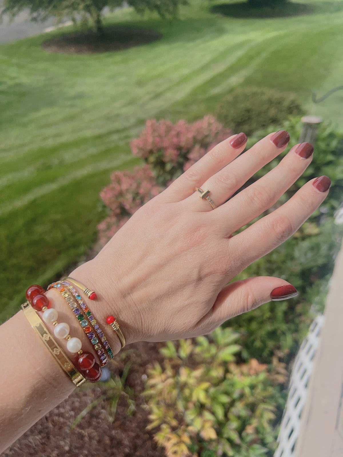 VEITA Jewelry Clover Bangle styled on the wrist with colorful layered bracelets for fall