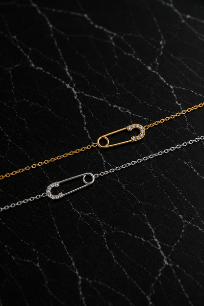 Delicate Salama Bracelet featuring a minimalist safety pin design in gold and silver finishes crafted from stainless steel with zircon accents.