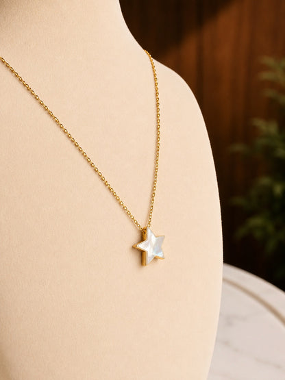 Gold necklace with a star-shaped shell pendant.