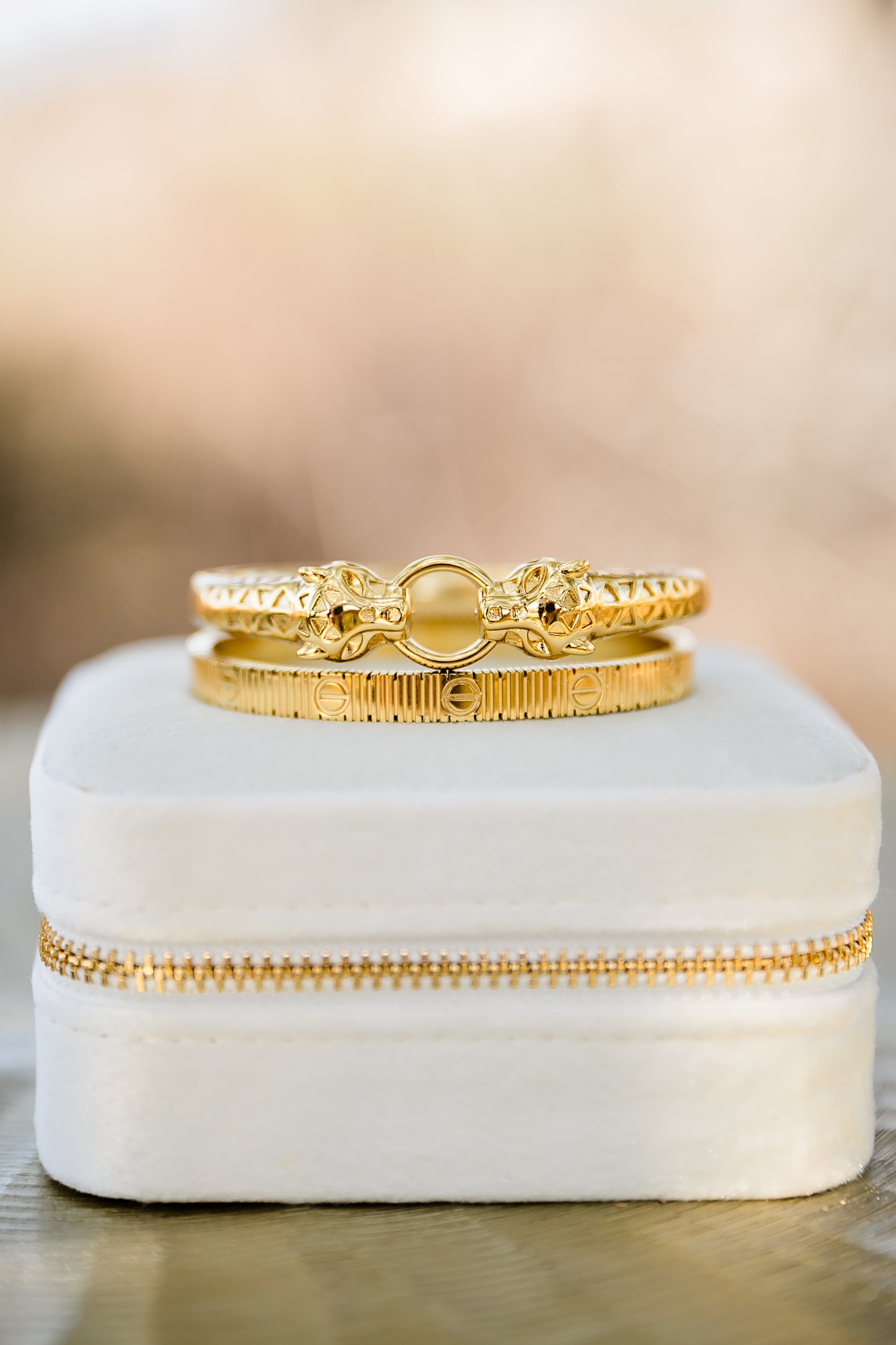 Close-up of Feline bangle (top) and Vesper textured gold bangle showing detailed finish, hinged closure, and polished 18kt gold plating