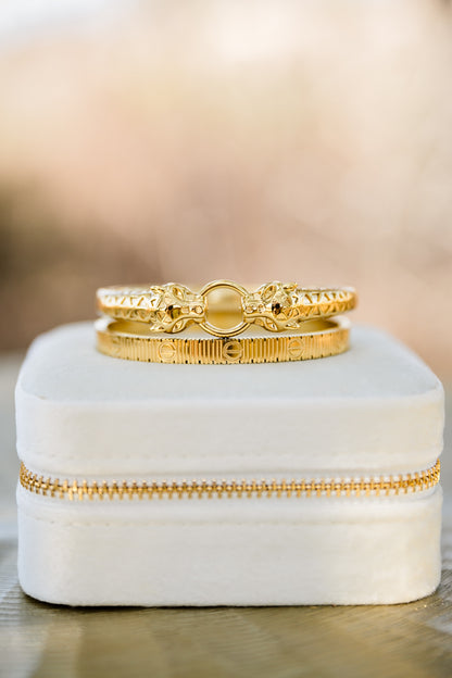 Close-up of Feline bangle (top) and Vesper textured gold bangle showing detailed finish, hinged closure, and polished 18kt gold plating
