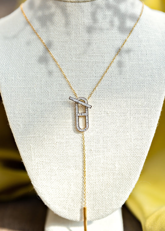 Gold necklace with a unique pendant on a mannequin bust.