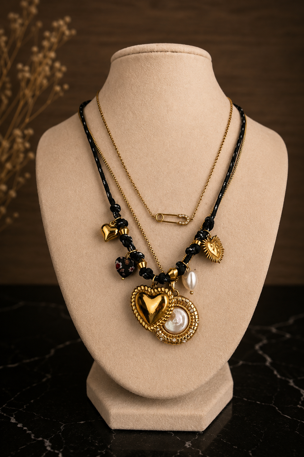 Indigo Necklace layered with a gold pendant necklace, featuring black beads and a dimensional gold heart charm.