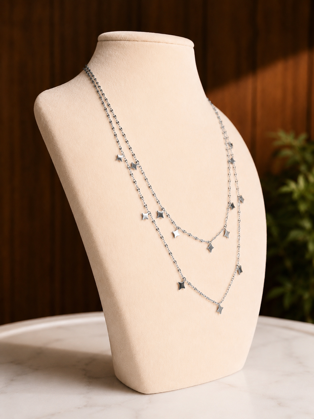 Side angle of the Light Up The Night Necklace showcasing layered gold chains with blue gemstone bead accents on a jewelry display.