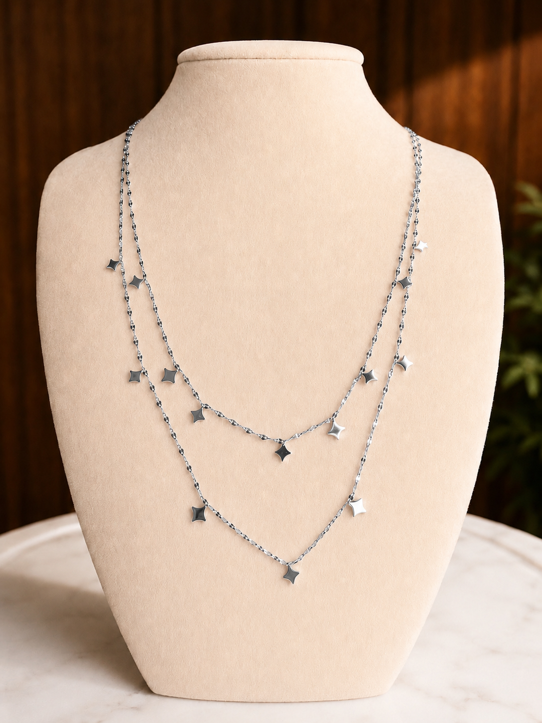 Light Up The Night Necklace featuring layered 18kt gold-plated chains with blue gemstone bead accents displayed on a jewelry bust.