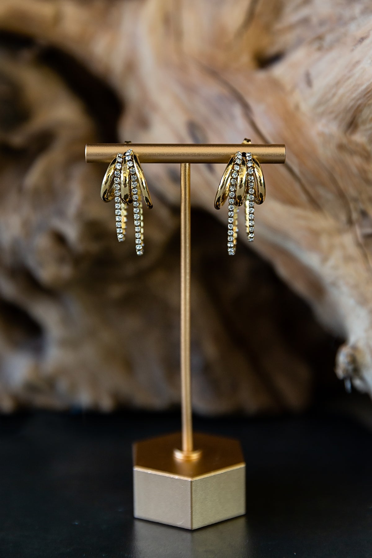 Marisol Hoop Earrings featuring a gold triple-hoop design with zircon stone details displayed on an earring stand.