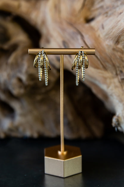 Marisol Hoop Earrings featuring a gold triple-hoop design with zircon stone details displayed on an earring stand.