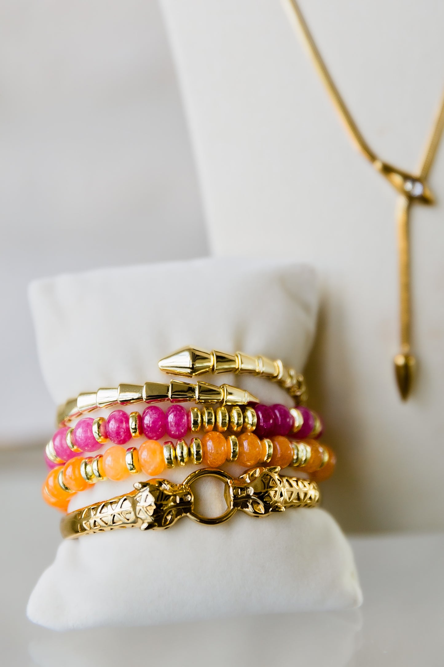 Night Coil gold bangle styled with colorful bracelets in a stacked wrist look highlighting versatile layering options