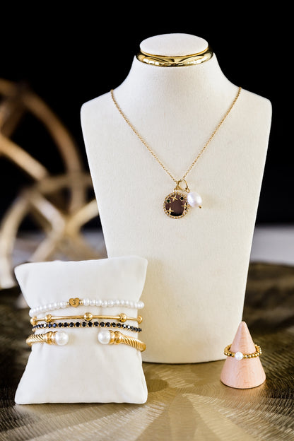 Jewelry set including a necklace, bracelets, and rings displayed on a mannequin bust.