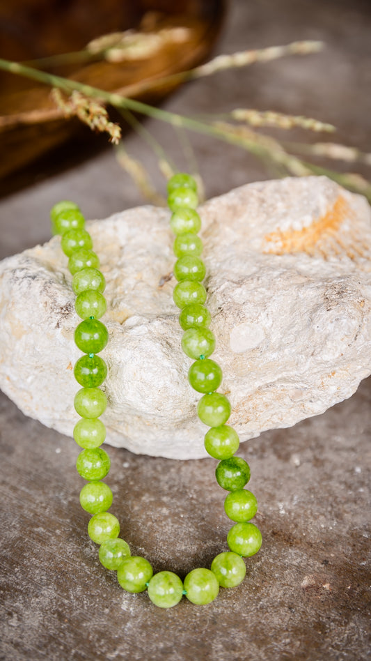 VEITA Jewelry Peridot Necklace featuring vibrant green peridot stones displayed on natural stone