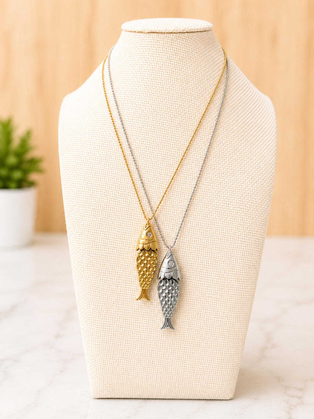 Pesce d'Oro Necklace featuring textured gold and silver fish pendants on delicate ball station chains crafted from stainless steel.