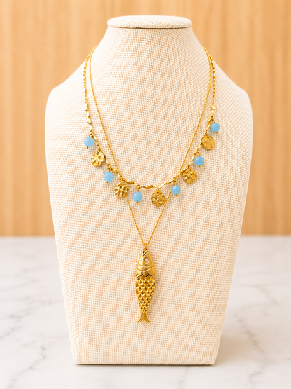 Gold Pesce d'Oro Necklace featuring a textured fish pendant on a delicate ball station chain crafted from 18kt gold plated stainless steel.