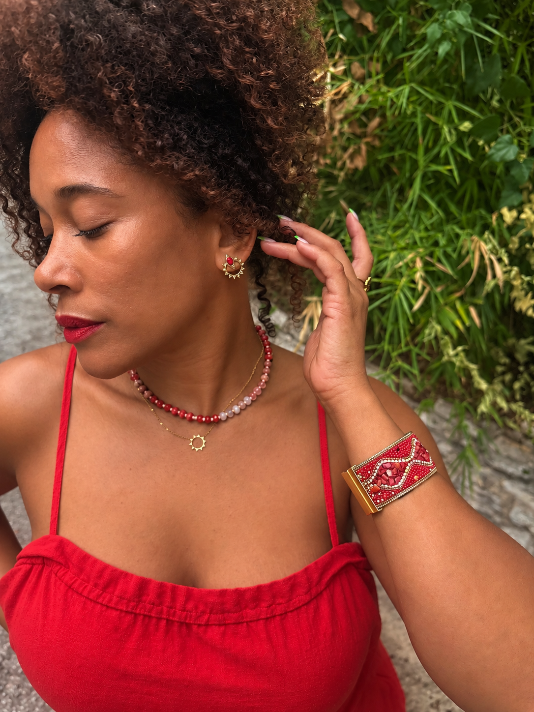 Model wearing VEITA Jewelry Pyra Stud Earrings styled with a red top