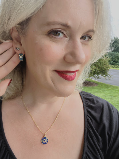 Model wearing the VEITA Jewelry Safira Necklace featuring a blue enamel protective eye pendant on a delicate gold chain