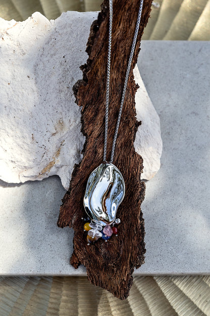 Sculptura Necklace from the LUNA Collection displayed with its long chain and sculptural silver-tone pendant.