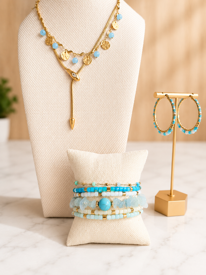 Seaside Earrings paired with the matching Seaside Necklace, featuring hand-beaded light blue accents and 18kt gold plated stainless steel.