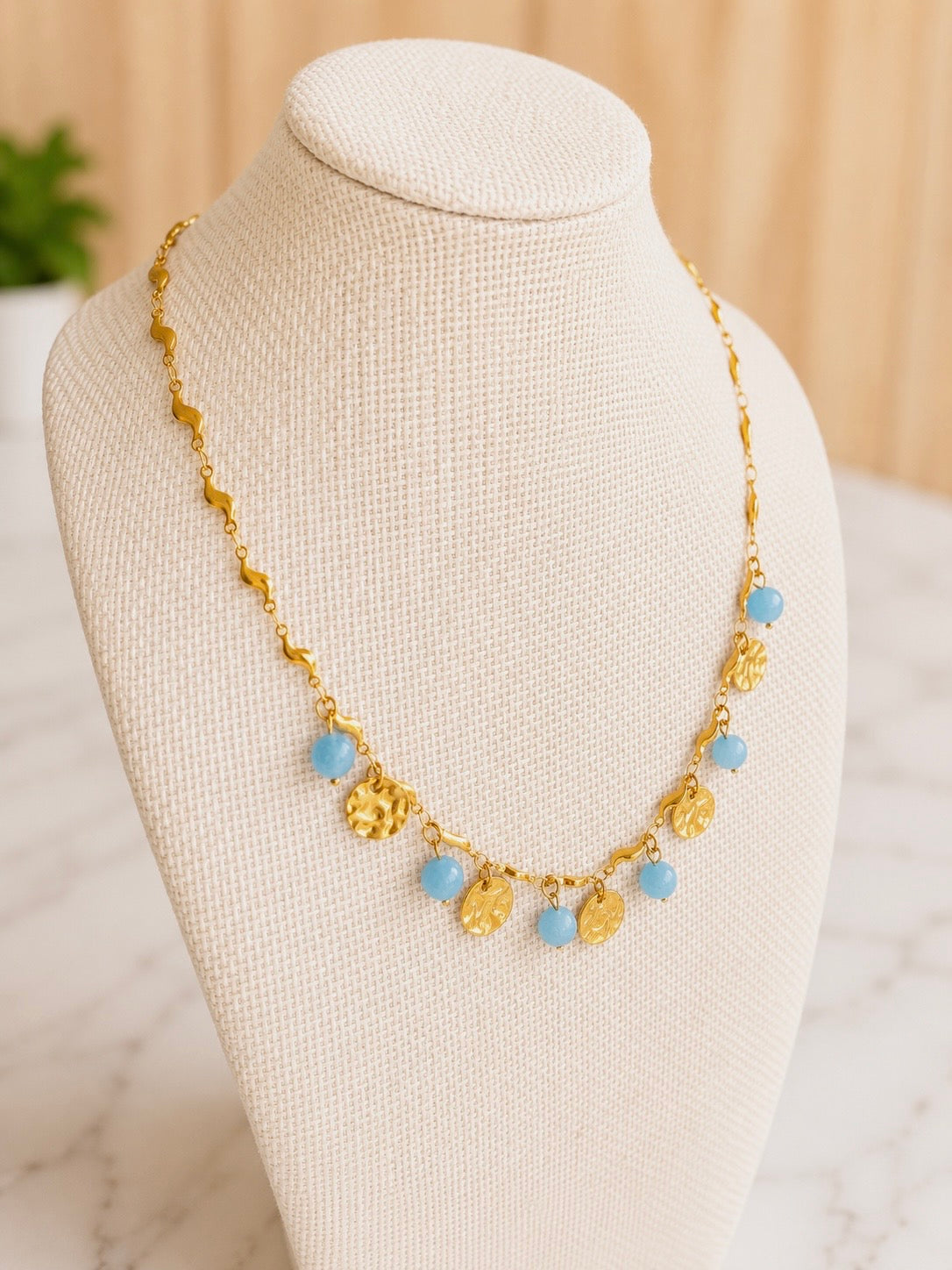 Seaside Necklace featuring hand-beaded light blue stones on an 18kt gold plated stainless steel chain.