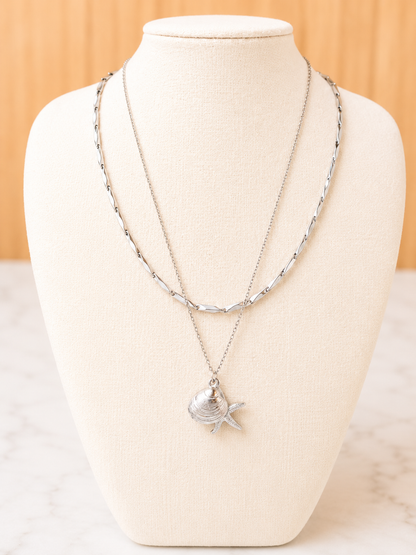 Shoreline Necklace in silver featuring delicate shell and starfish charms on a lightweight stainless steel chain.