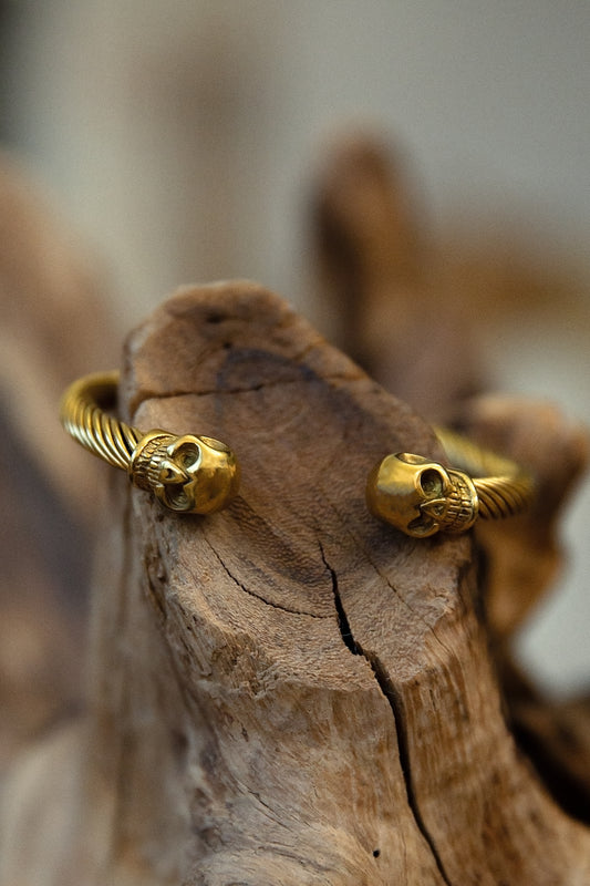 Gold bracelet on a wooden surface with a blurred background