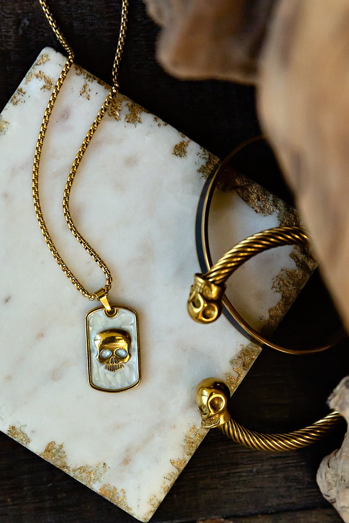 Gold necklace with a pendant on a marble surface