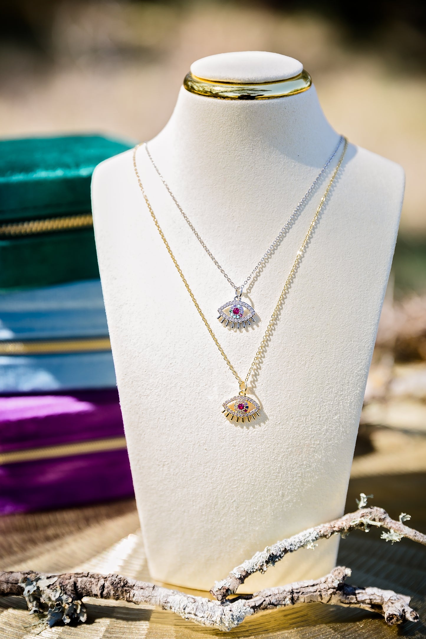 Spectral eye necklace featuring gold and silver evil eye pendants with multicolor zircon stones displayed in layered styling