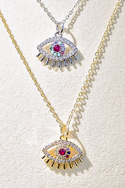 Spectral eye necklace featuring gold and silver evil eye pendants with multicolor zircon stones displayed in layered styling closeup