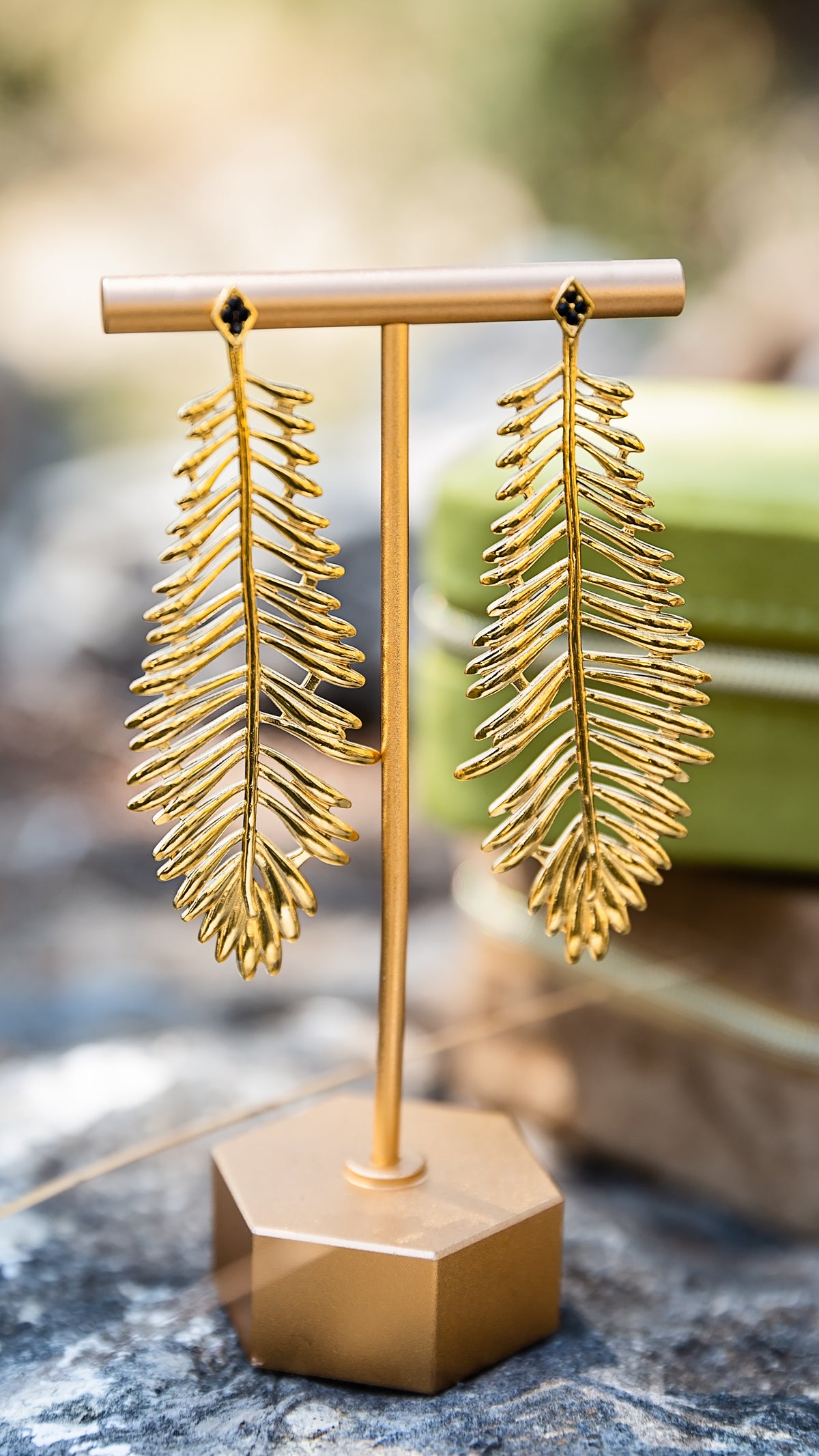 Thalia Earrings featuring statement gold leaf drops with black crystal accents.