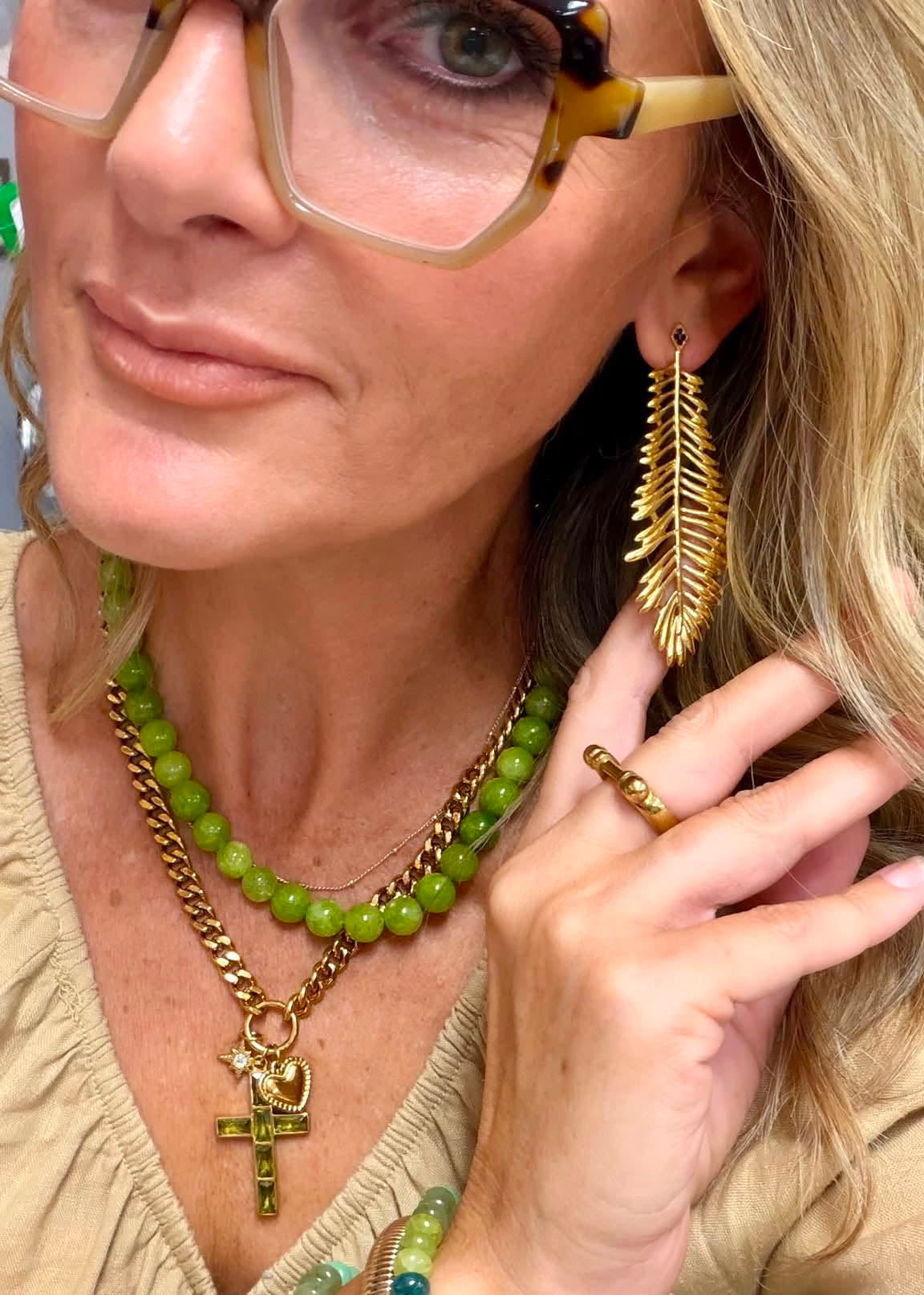Thalia Earrings worn for a bold layered fall jewelry look with gold leaf details, with Selah Necklace with thick cuban chain and decorated cross.