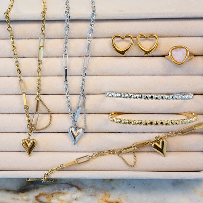 Jewelry set including heart pendant necklaces and heart-shaped earrings on a suede jewelry tray.