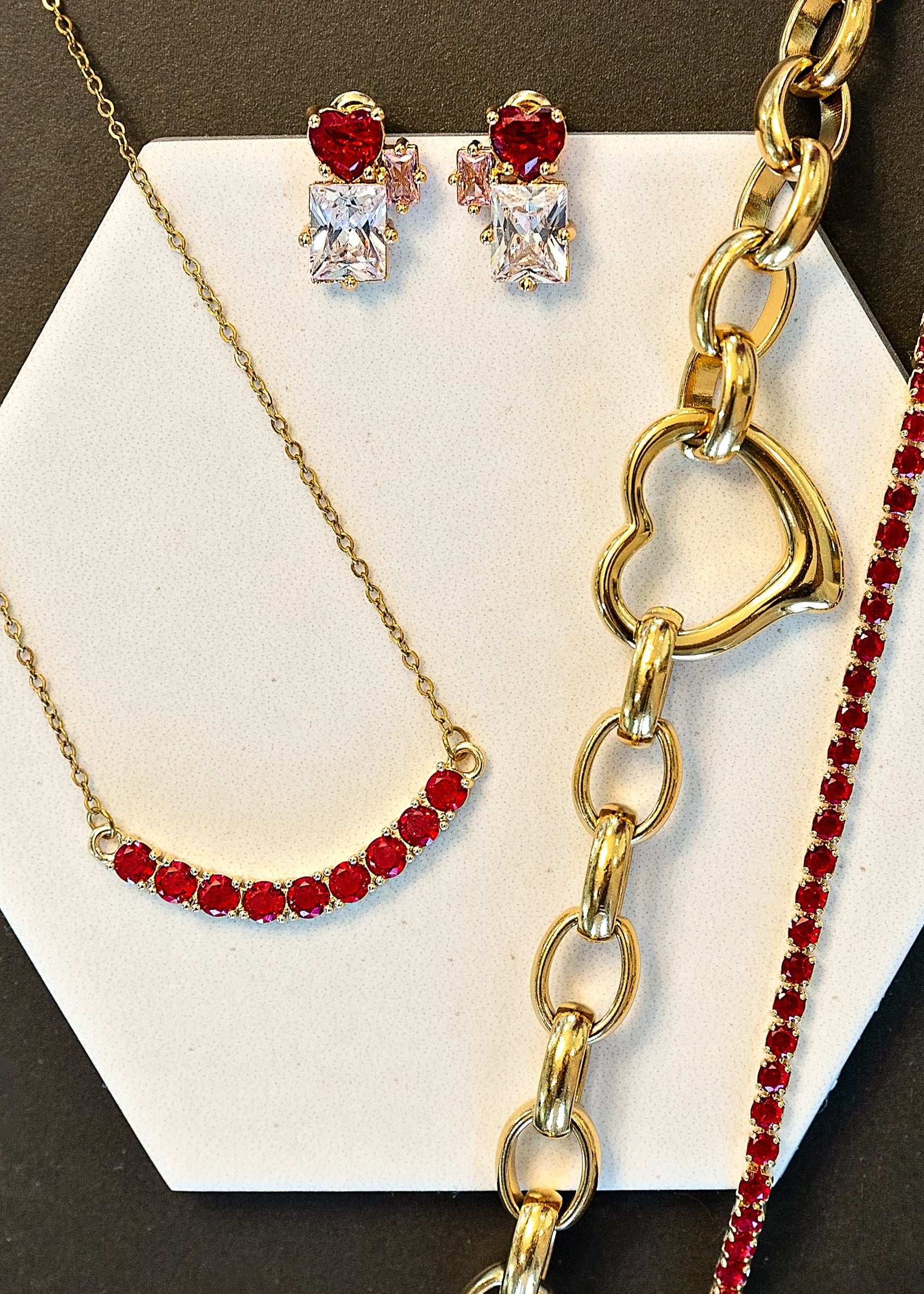 Jewelry set with necklace, bracelet, and earrings on a hexagonal white card.