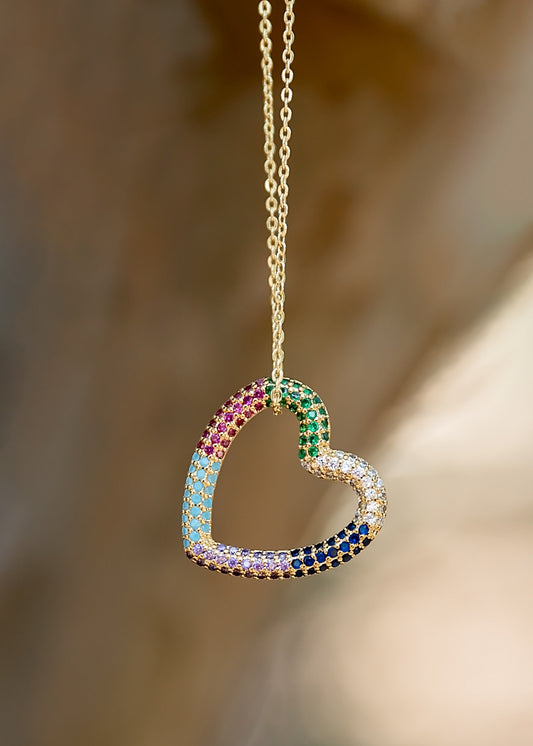 Heart-shaped necklace with colorful gemstones on a blurred background