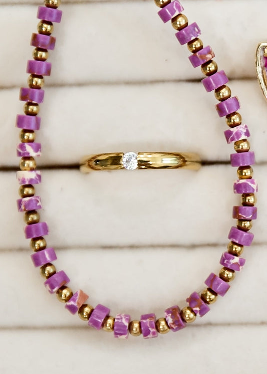 Jewelry set with purple and gold necklaces, earrings, and bracelet on a white background