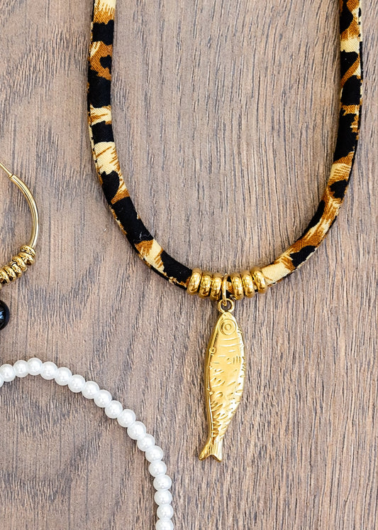 Jewelry set including hoop earrings, a necklace, and bracelets on a wooden surface