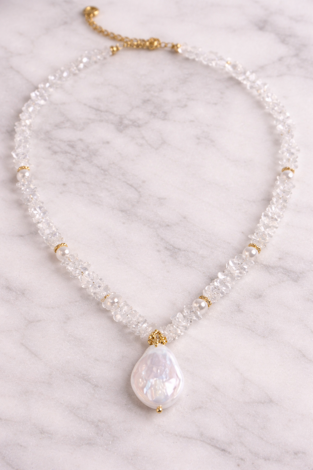 Necklace with a large pearl pendant on a marble background